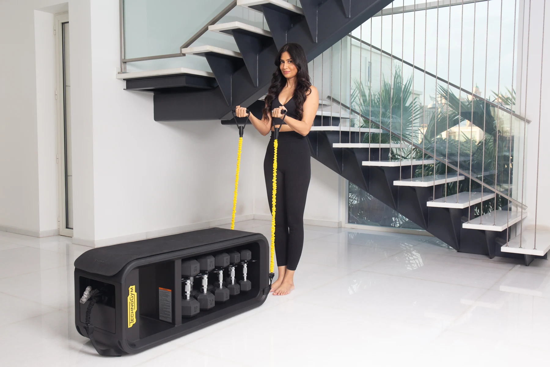 Uma practising movement with resistance bands beside a staircase