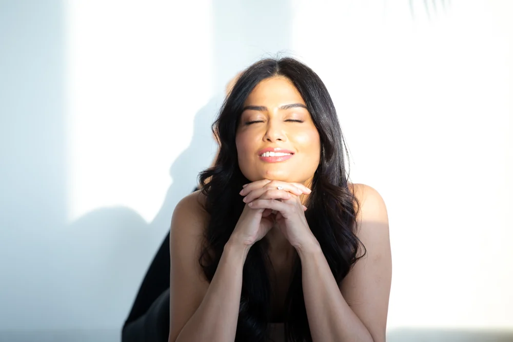 Uma resting her hands beneath her chin in a quiet moment of stillness
