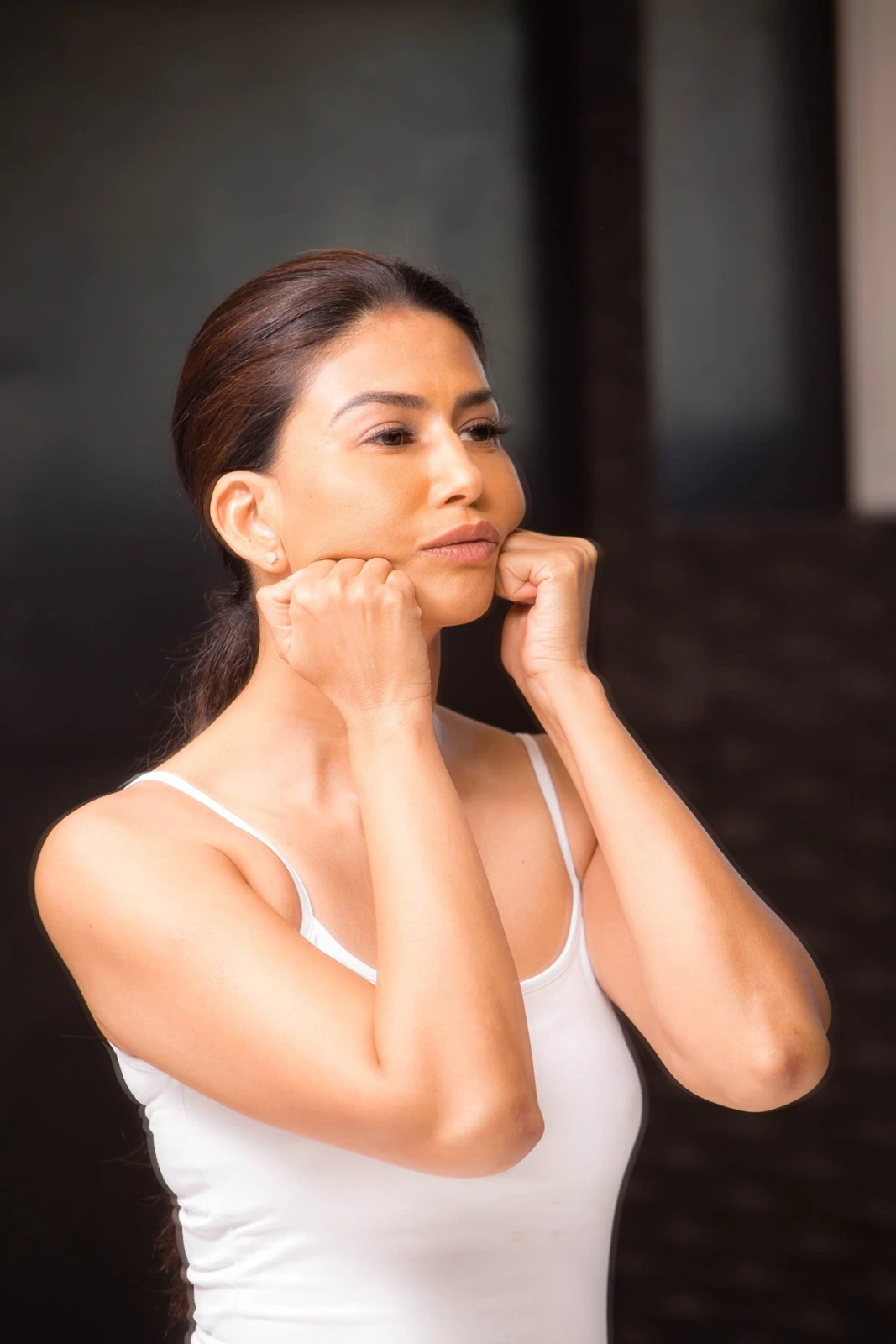 Uma demonstrating massage along her jawline