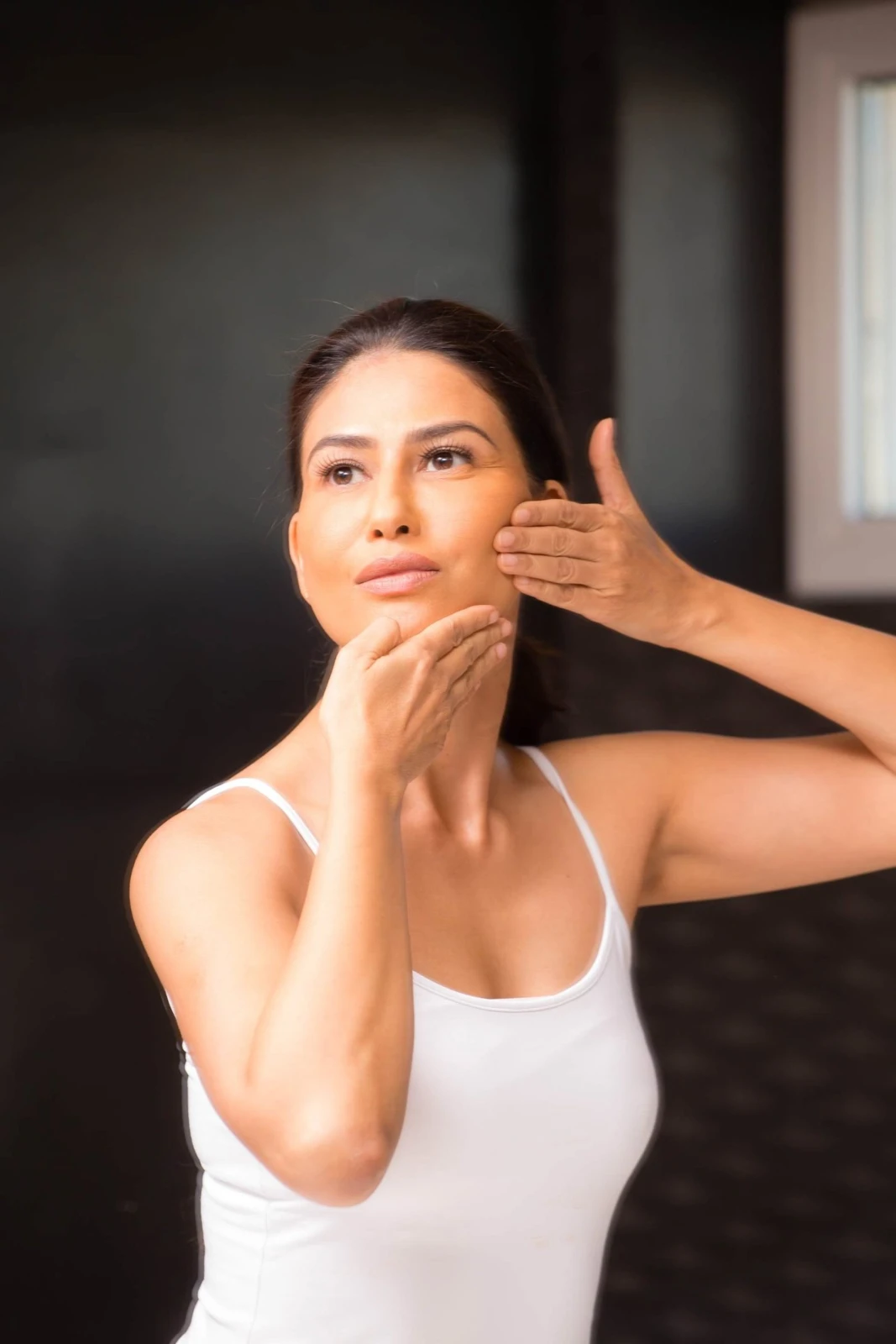 Uma demonstrating massage along her lower face