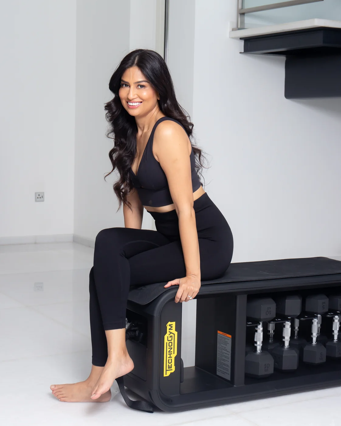 Uma Ghosh in activewear seated on her home training bench