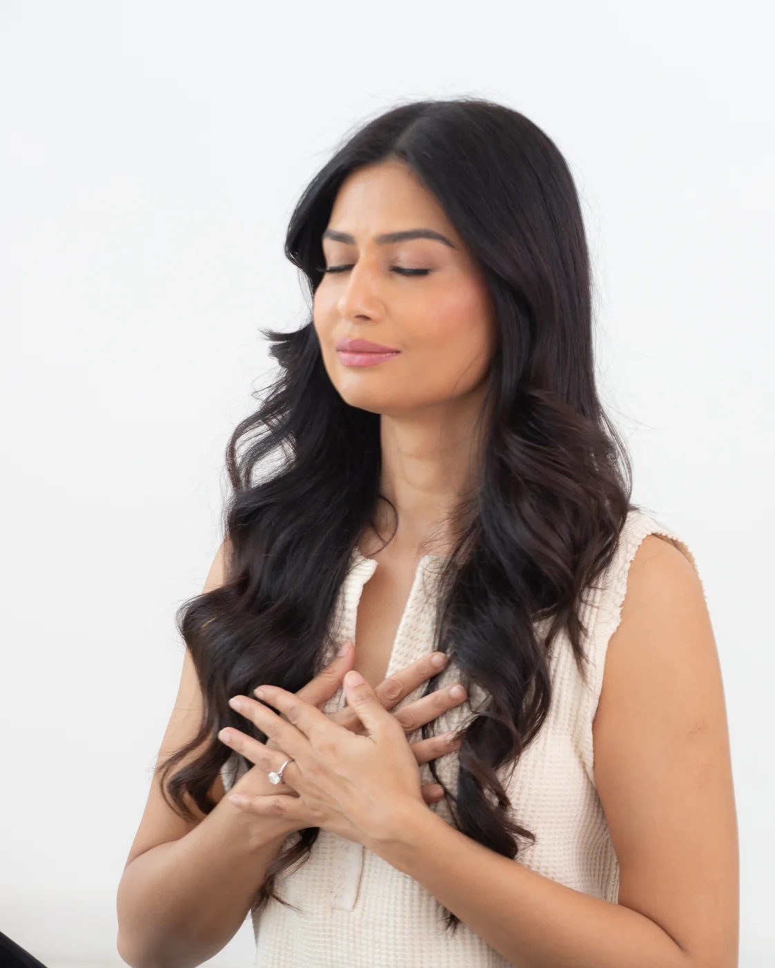 Uma Ghosh with her hands on her chest, eyes closed