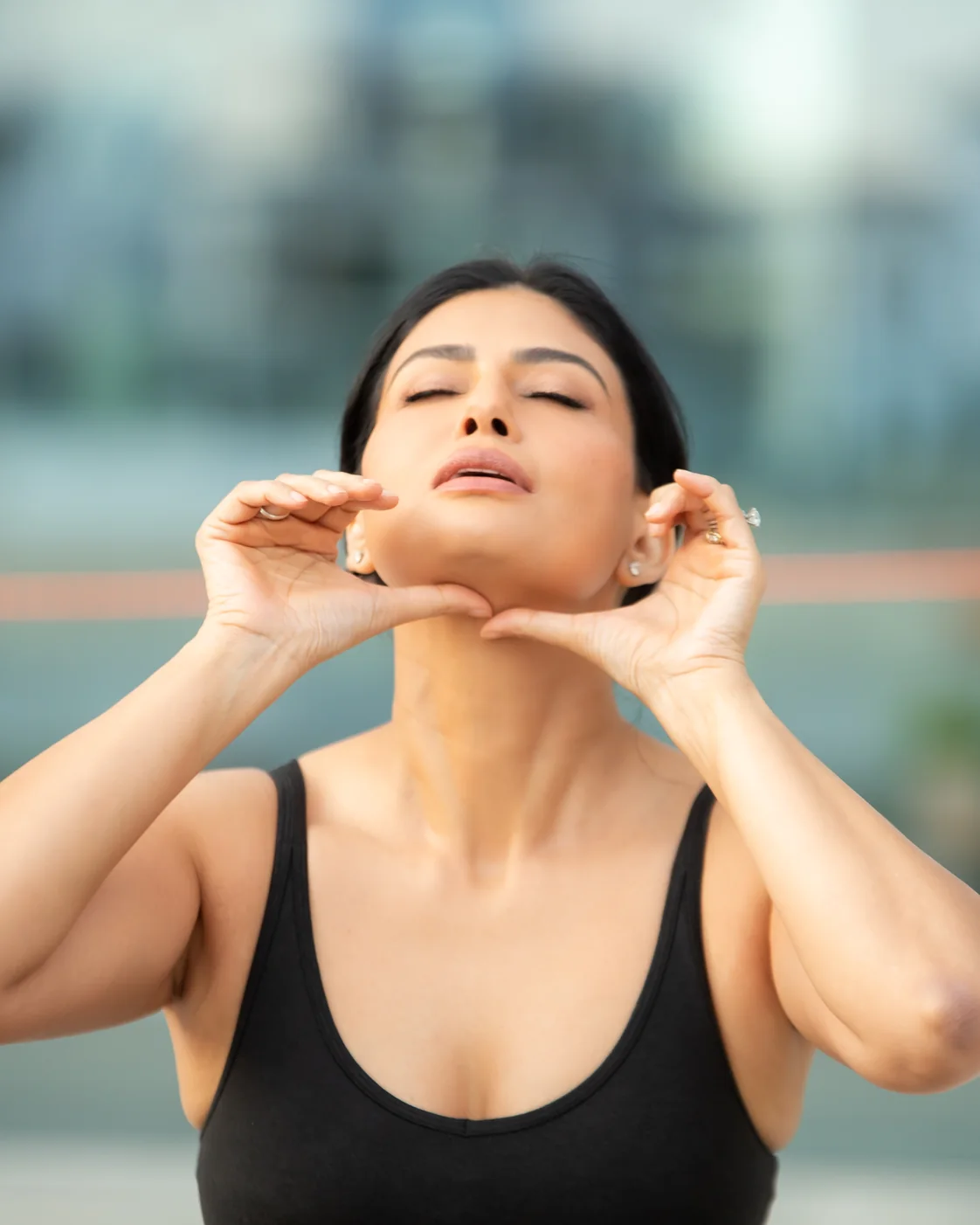 Uma demonstrating hand placement along her jaw and cheeks