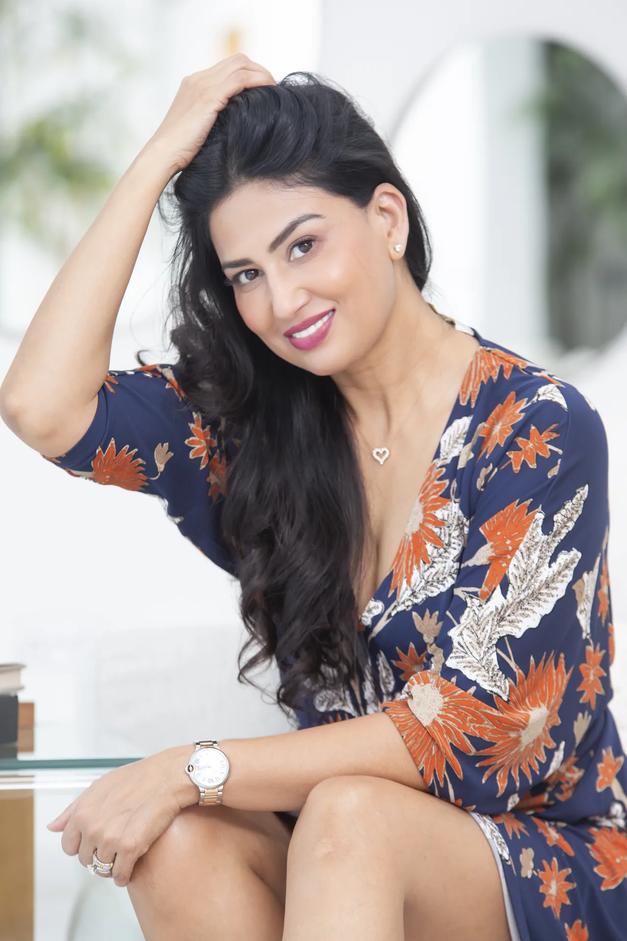 Uma Ghosh in a floral dress with one hand in her hair