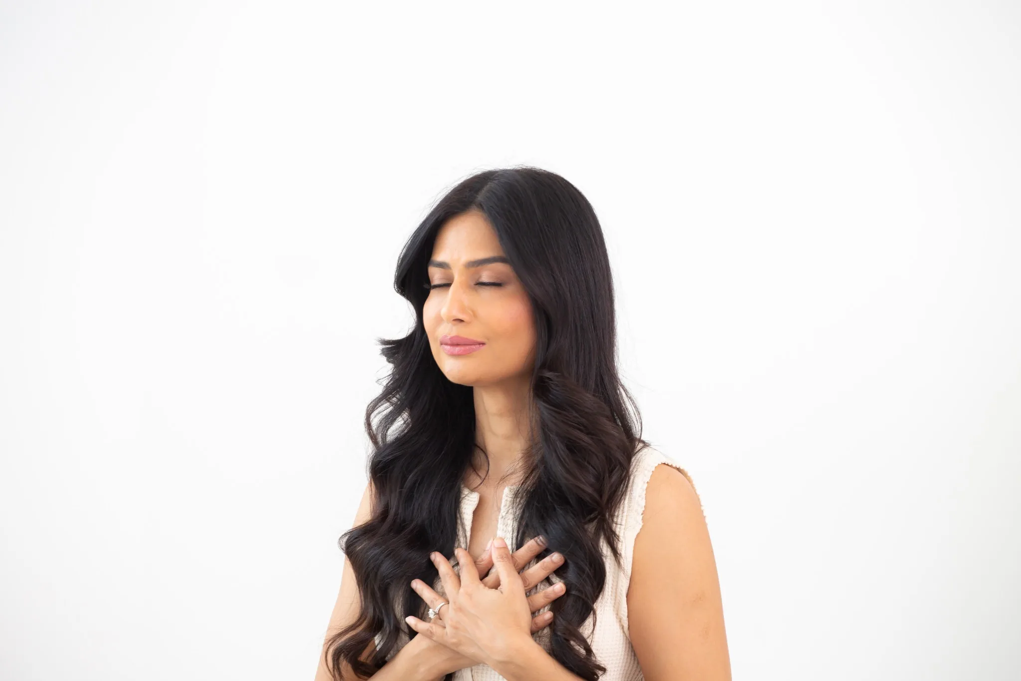 Uma with eyes closed and both hands resting over her heart